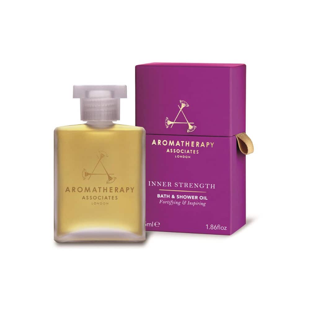 Inner Strength Bath & Shower Oil bottle with purple box, yellow oil, and golden logo