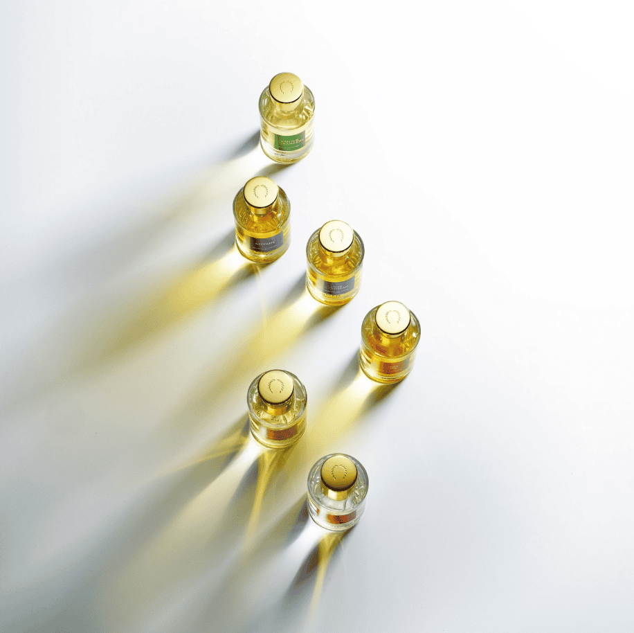 Assortment of luxurious glass perfume bottles with gold caps and yellow liquid