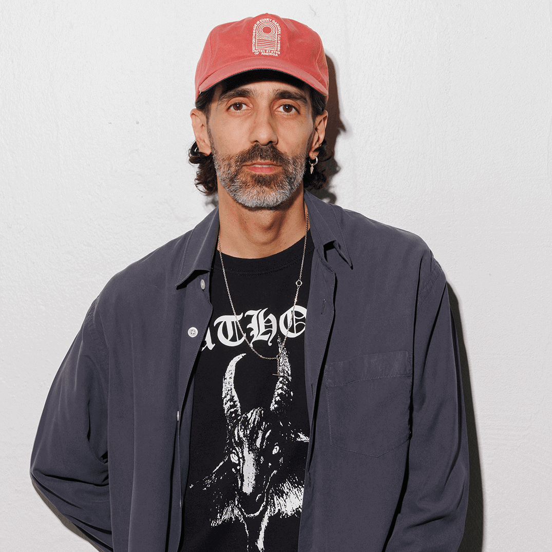 Man wearing a red hat and a black t-shirt with a goat graphic
